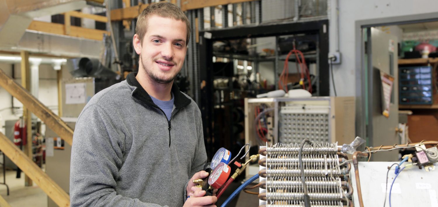 HVAC student working with an HVAC unit.