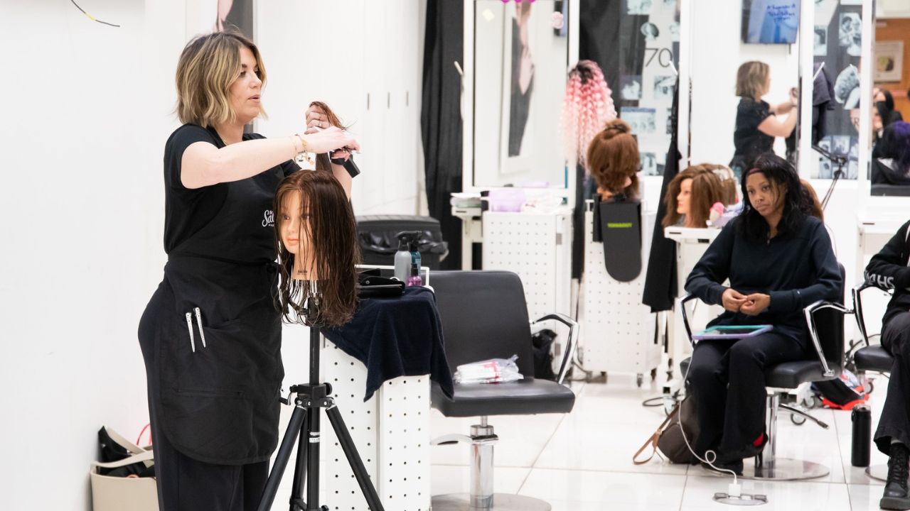 A salon owner conducts a training session for Penn Commercial Toni & Guy cosmetology students