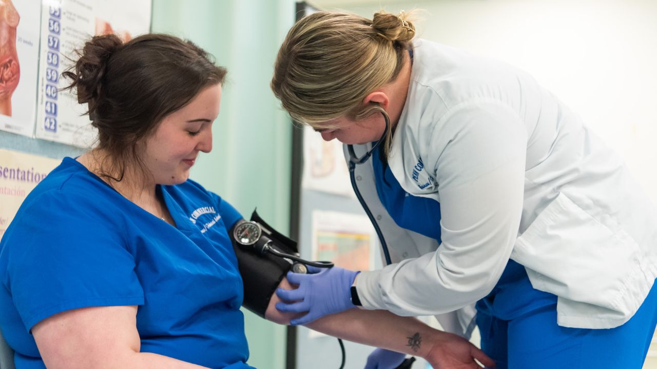 A Penn Commercial nursing student takes the blood pressure of another Penn Commercial student