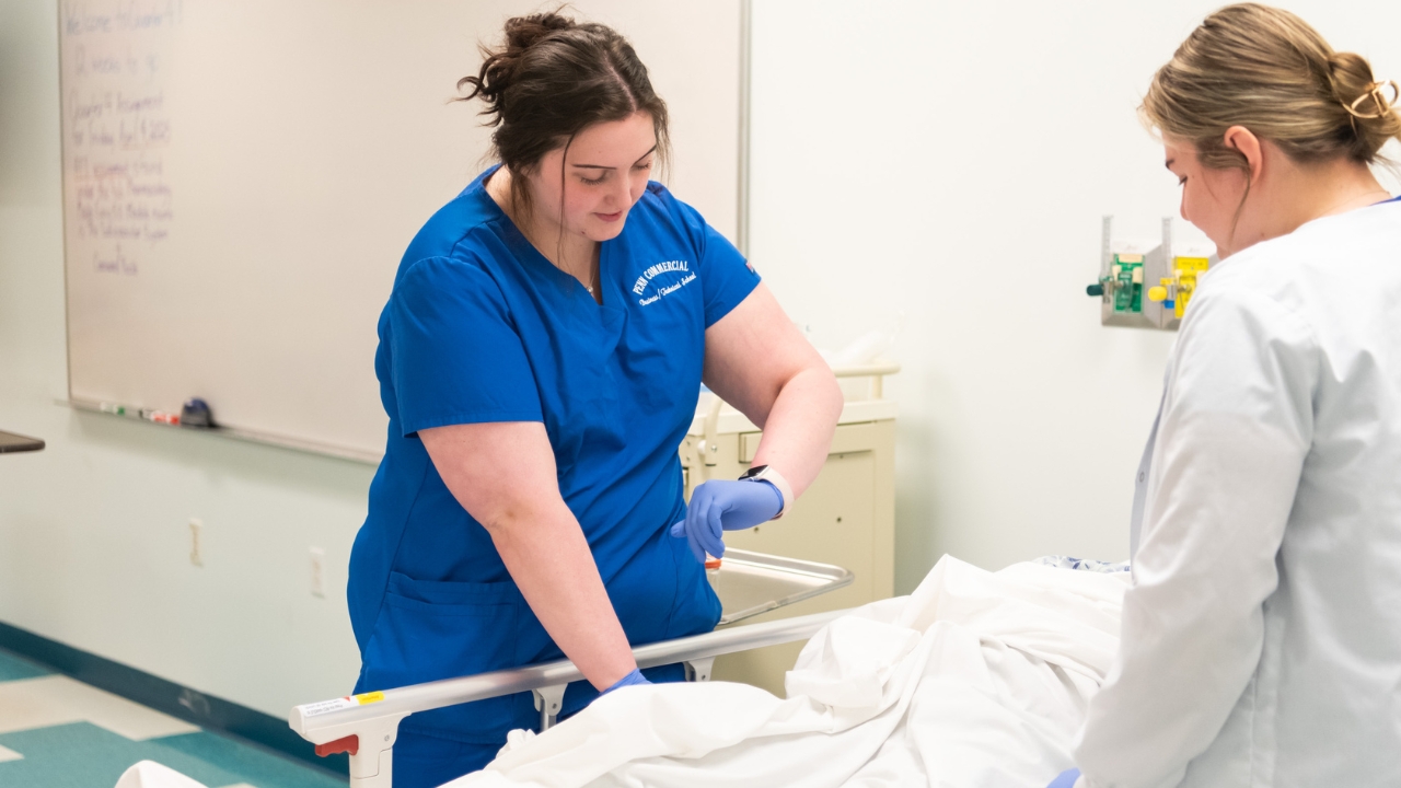 A Penn Commercial practical nursing student checks the vitals of a sample patient
